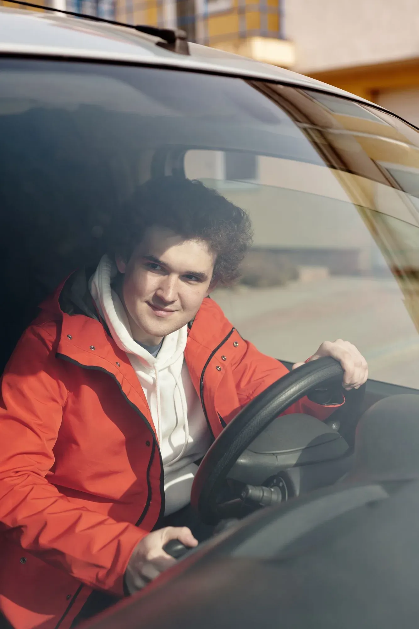 Lächelnder Fahrschüler am Steuer eines Fahrschulwagens