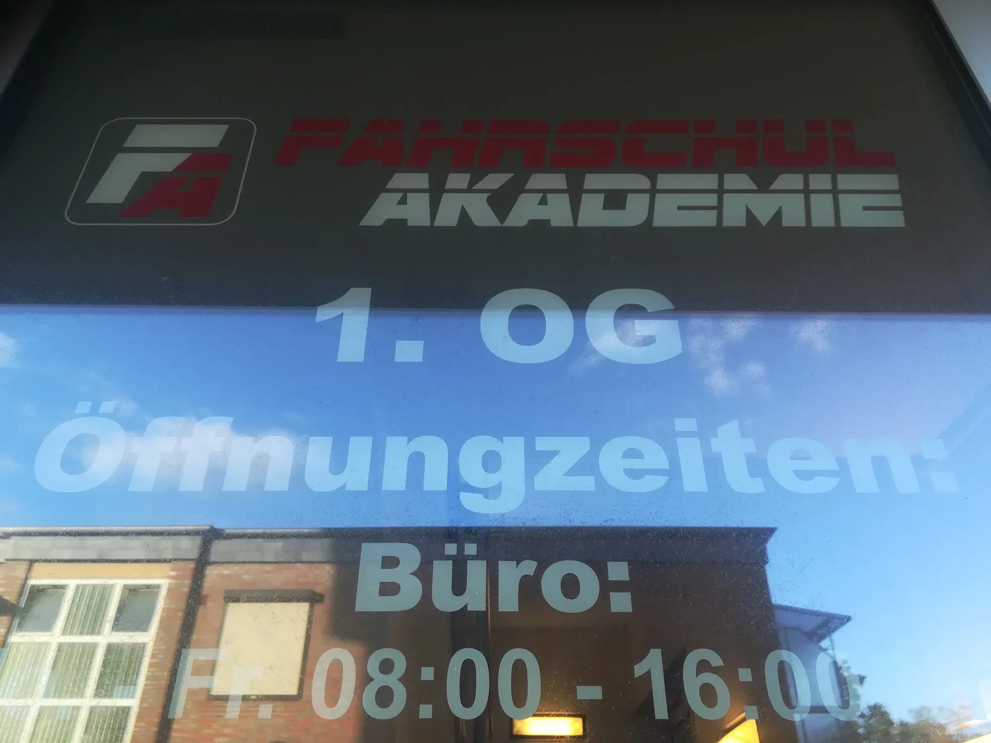 Standort der Fahrschul-Akademie mit Öffnungszeiten am Fenster